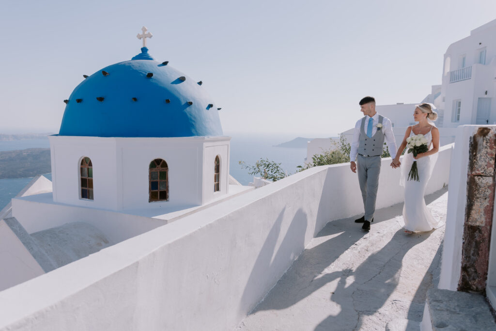 bride and groom walking through the streets of Santorini on their wedding day at le Ciel