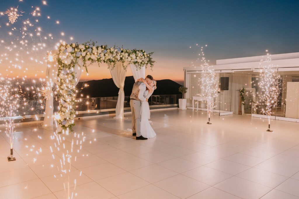 couple dancing surrounded by fireworks at le Ciel Santorini wedding