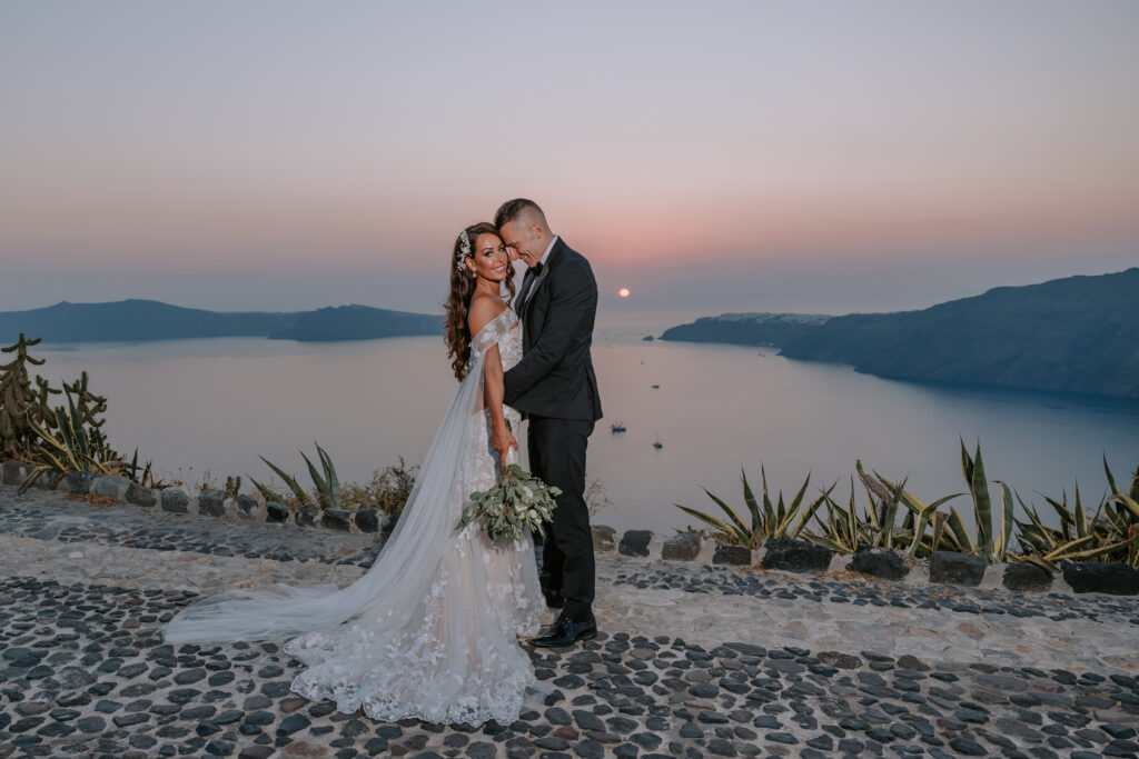 bride and groom embracing in front of a Santorini sunset