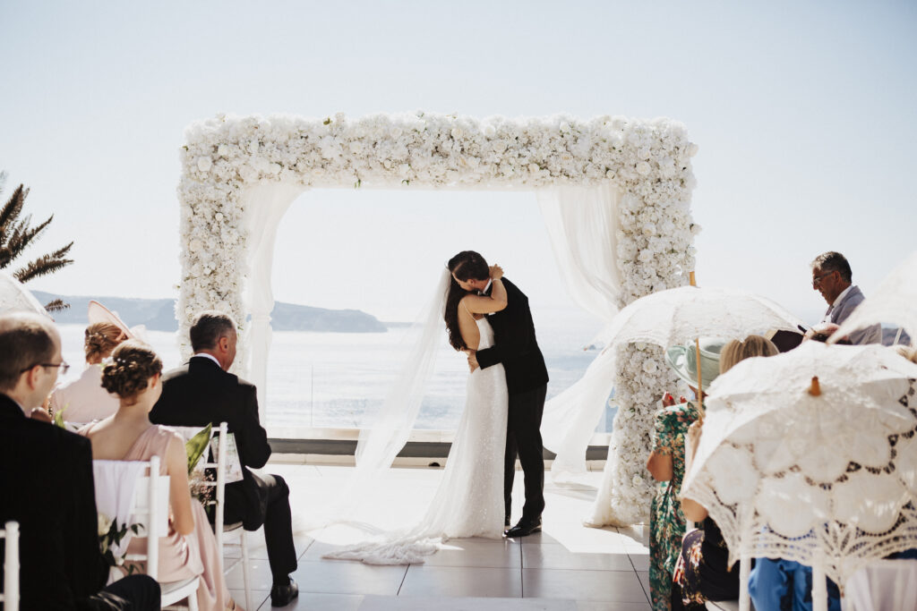 Bride and groom kissing at Le Ciel wedding venue in Santorini Greece