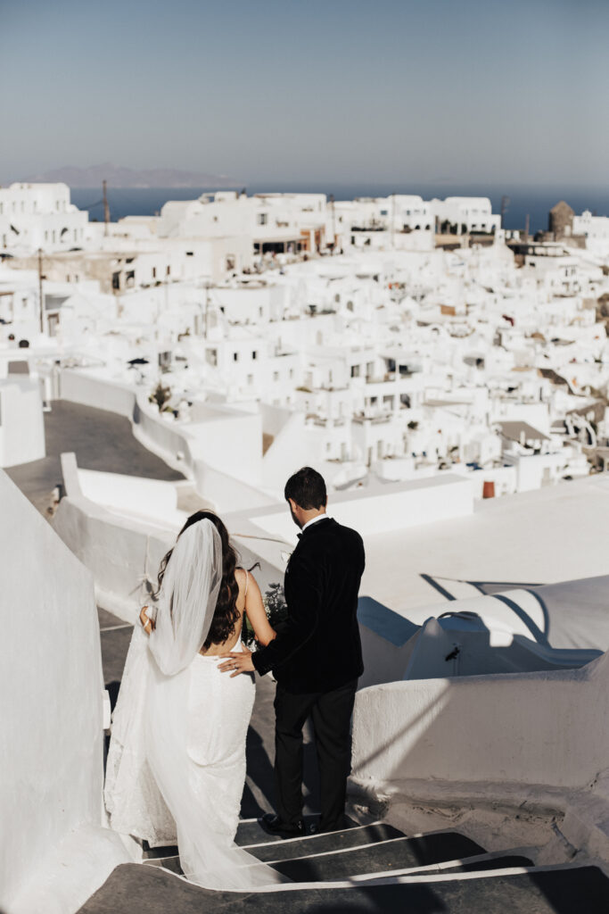 Bride and groom walking through  the streets of Santorini at a destination wedding in Greece