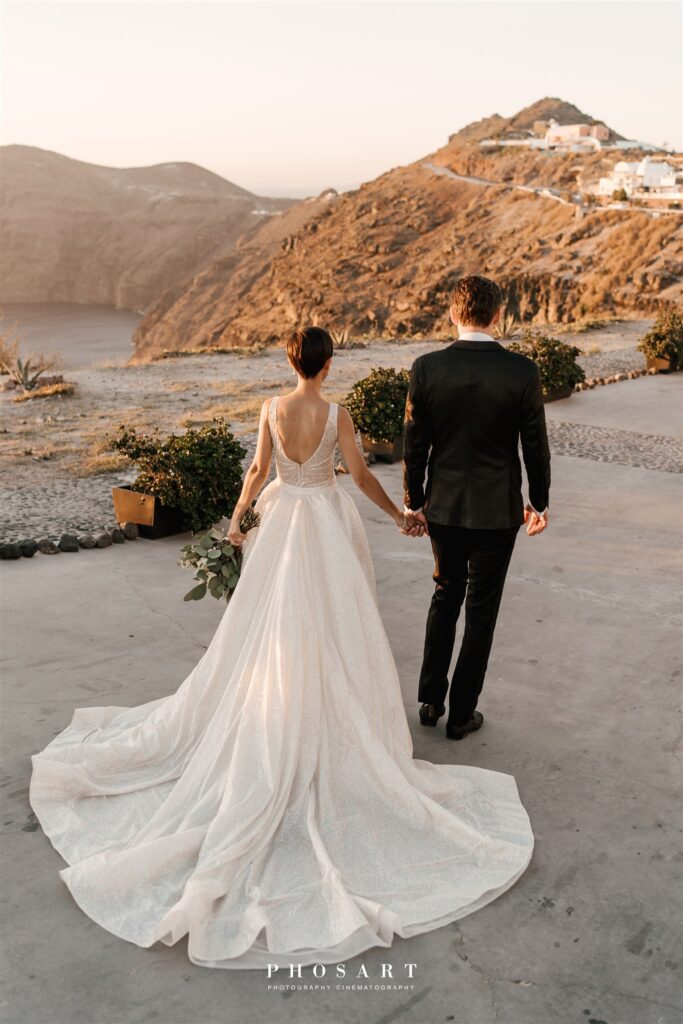 Bride and groom looking out across the sea and sunset at a destination wedding in Greece