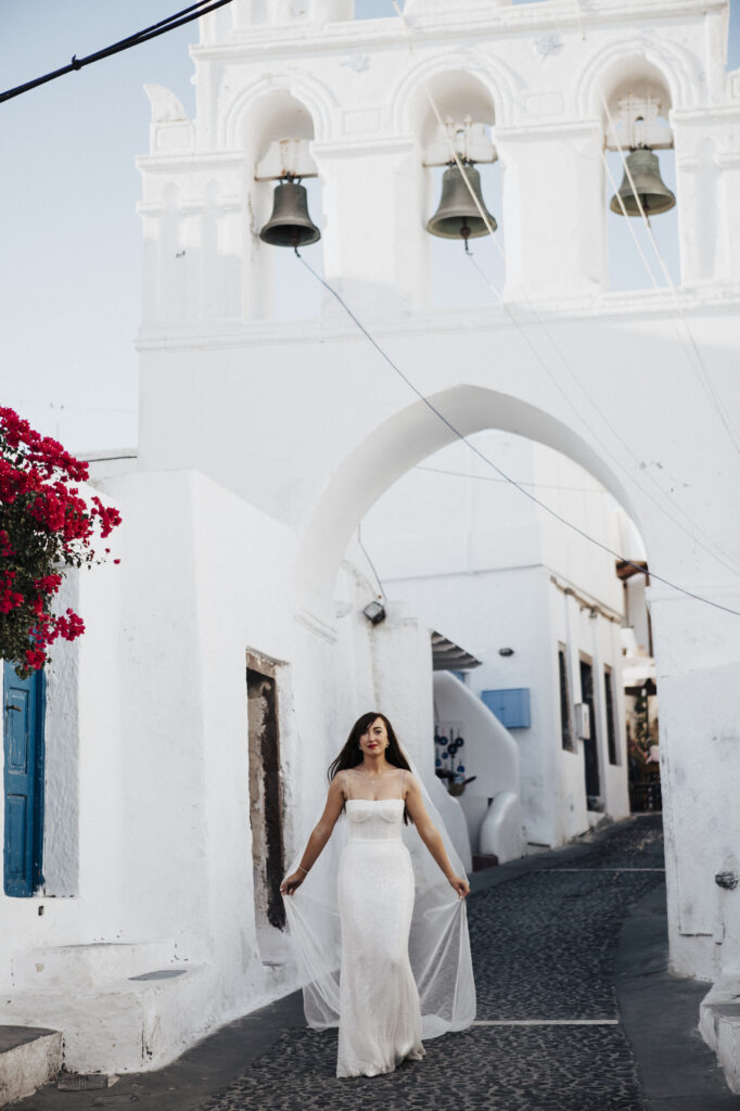 Bride walking through  the pretty old streets of Santorini
