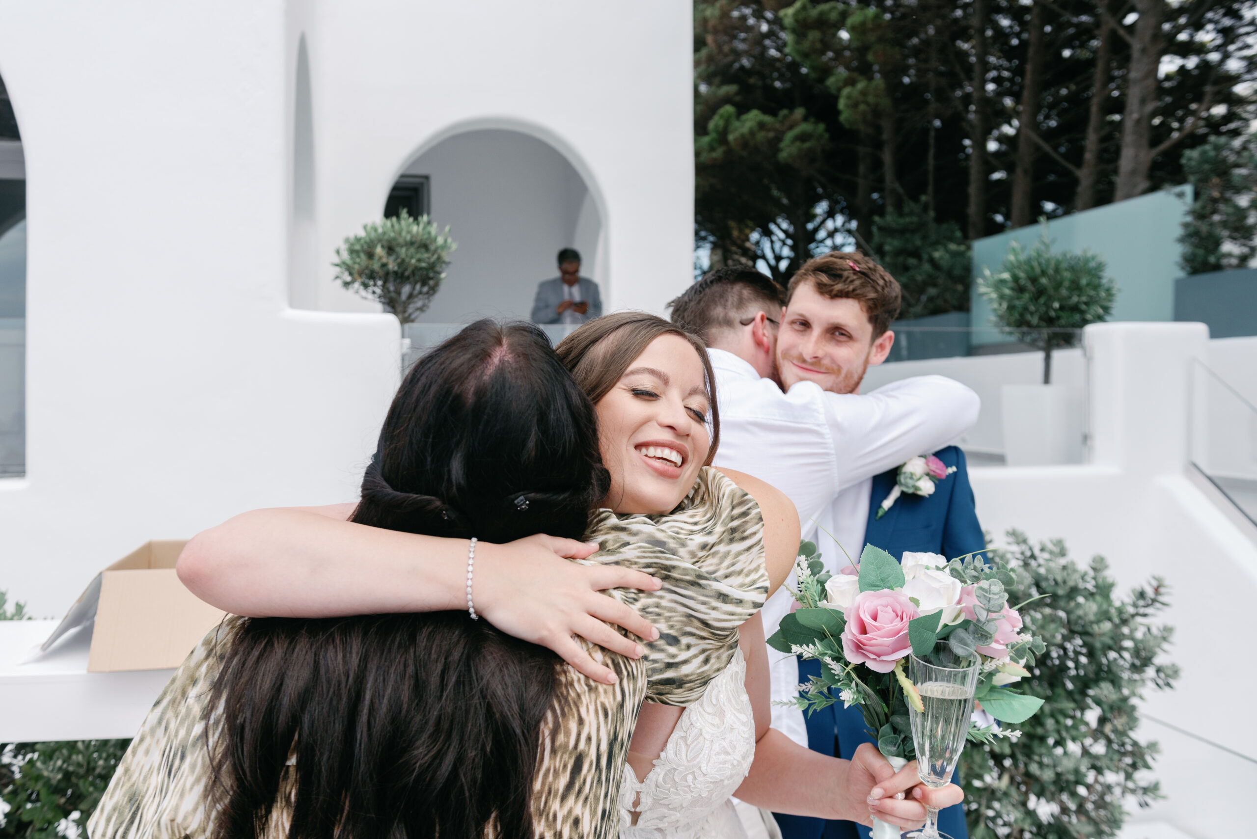 bride and groom embracing wedding guests at Le Ciel Santorini wedding