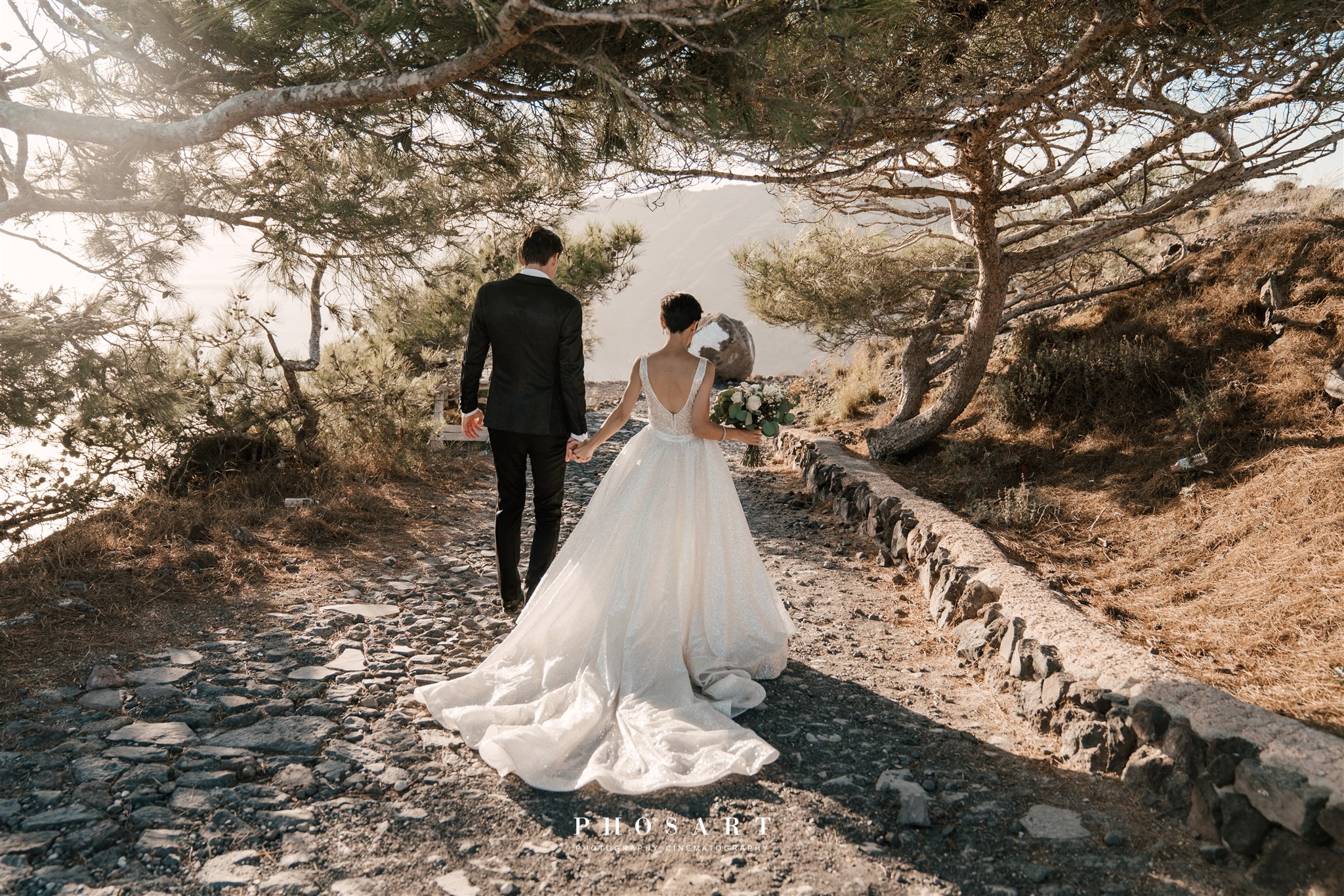 bride and groom walking through Santorini woodland