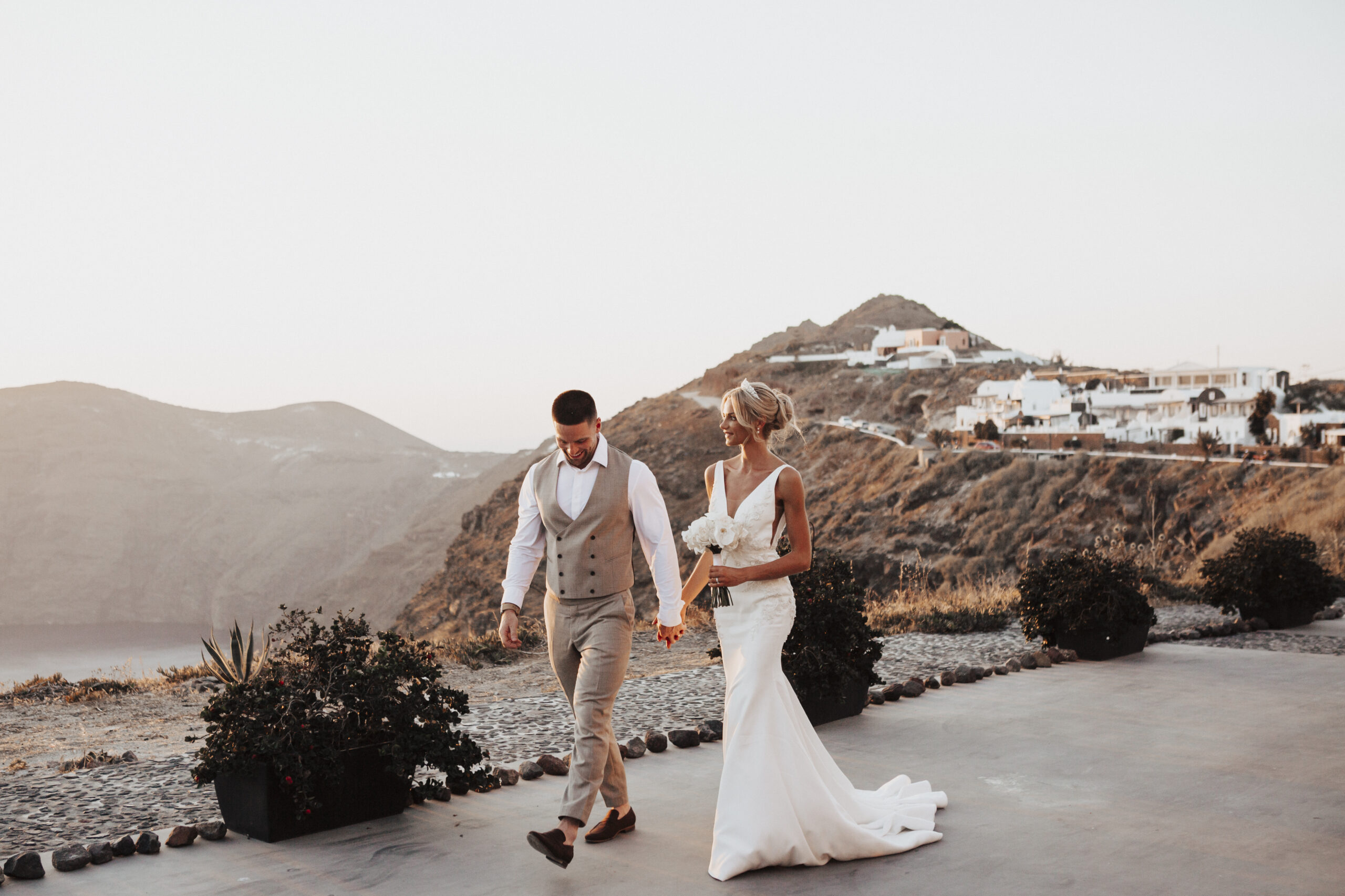 bride and groom walking along Santorini village
