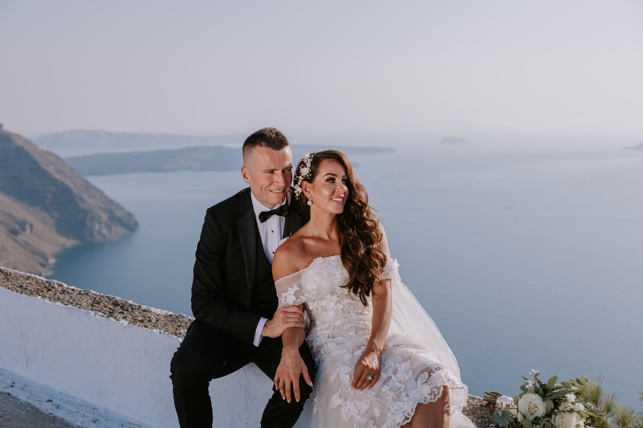 bride and groom sat overlooking the sea at their Santorini destination wedding