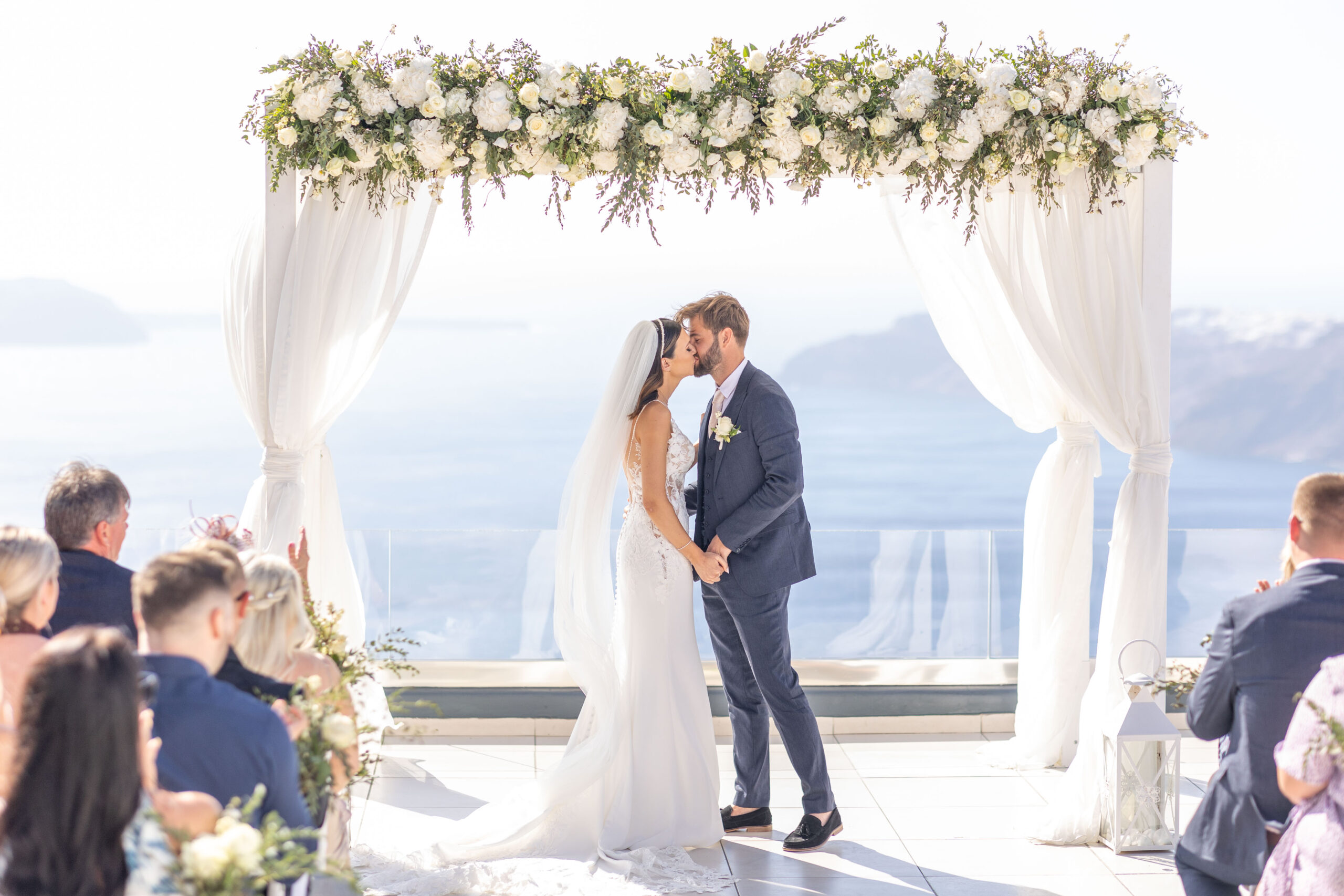 Bride and groom first kiss destination wedding photo at Le Ciel Santorini