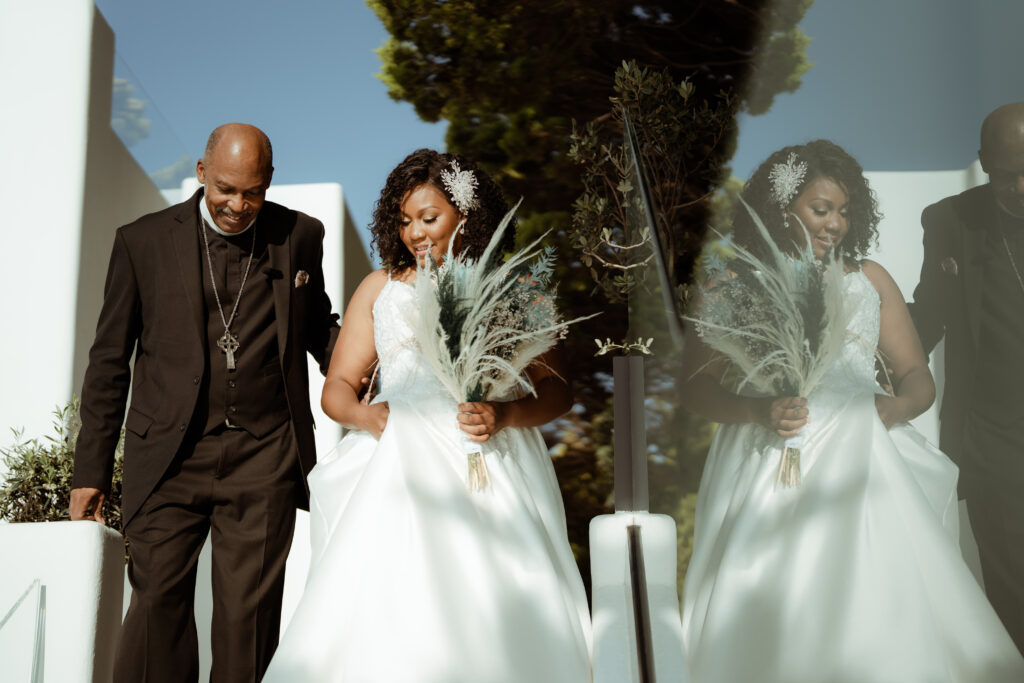 bride holding decorative grass bouquet walking with her father 