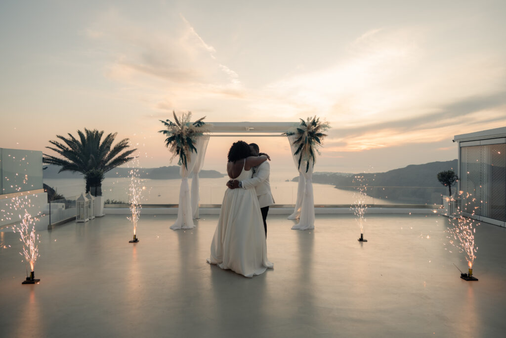 bride and groom dancing in front of a sunset at Le Ciel Santorini