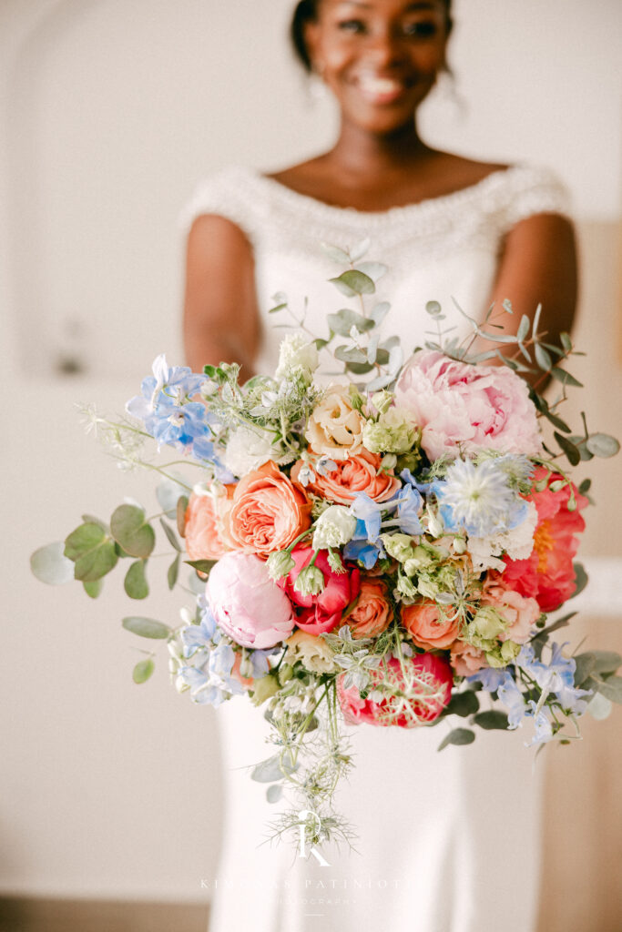 bride smiling holding a colourful wedding bouquet
