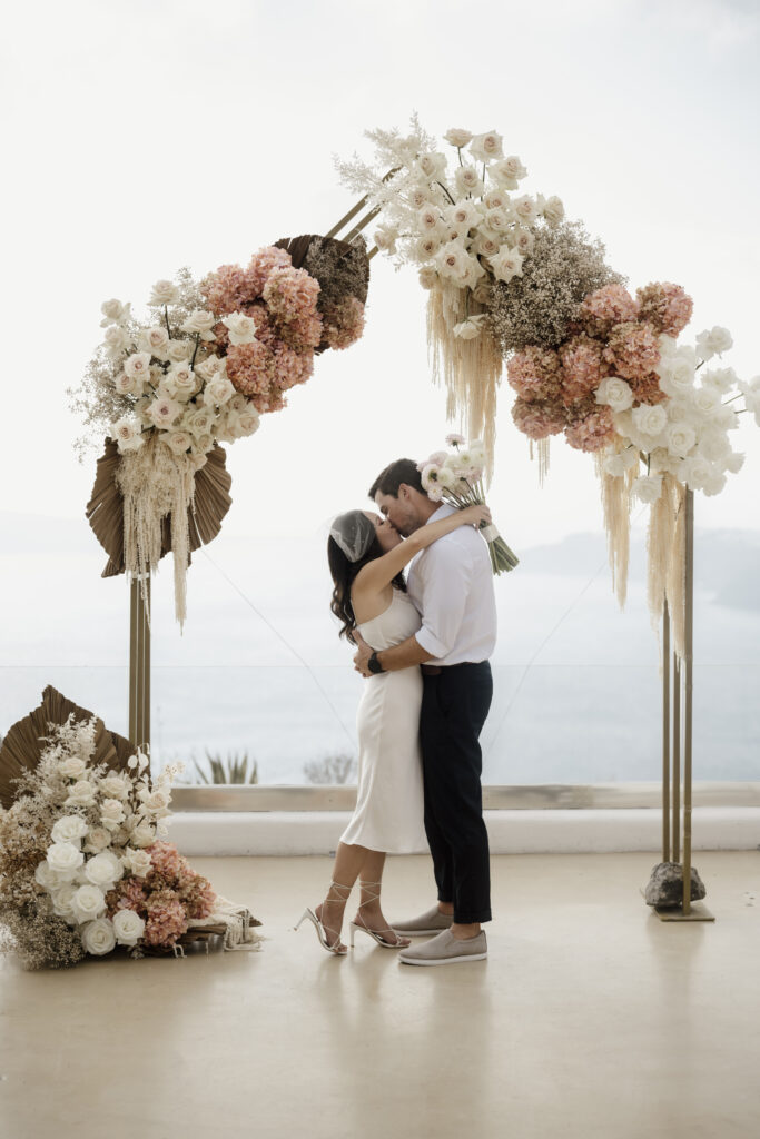 bride and groom kissing surrounded by statement wedding flowers