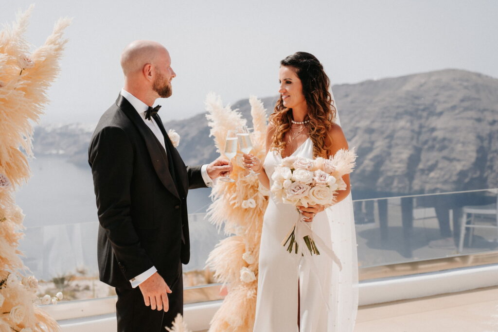 bride and groom at Le Ciel destination wedding in Santorini with warm neutral flowers