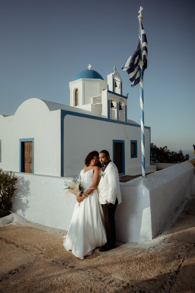 bride and groom looking relaxed together outside traditional white and blue greek building