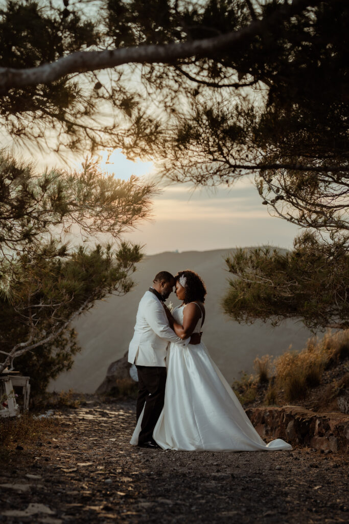 couple embracing in Santorini woodland with sun setting