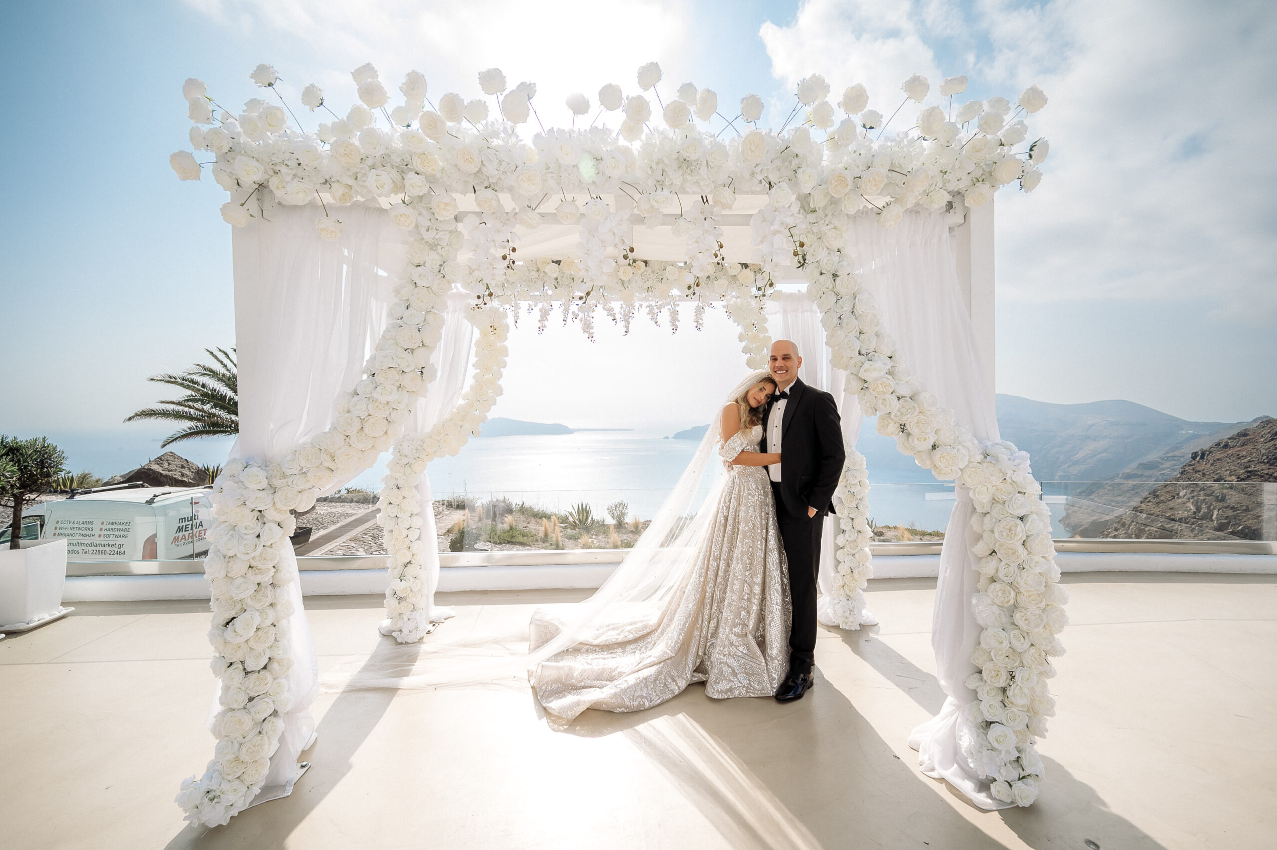 bride and groom embracing in front of aisle at Le Ciel Santorini