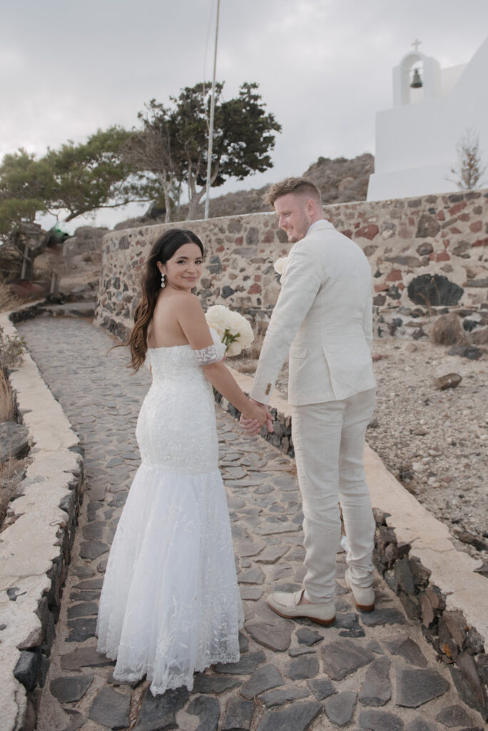 bride and groom smiling over their shoulders at the camera