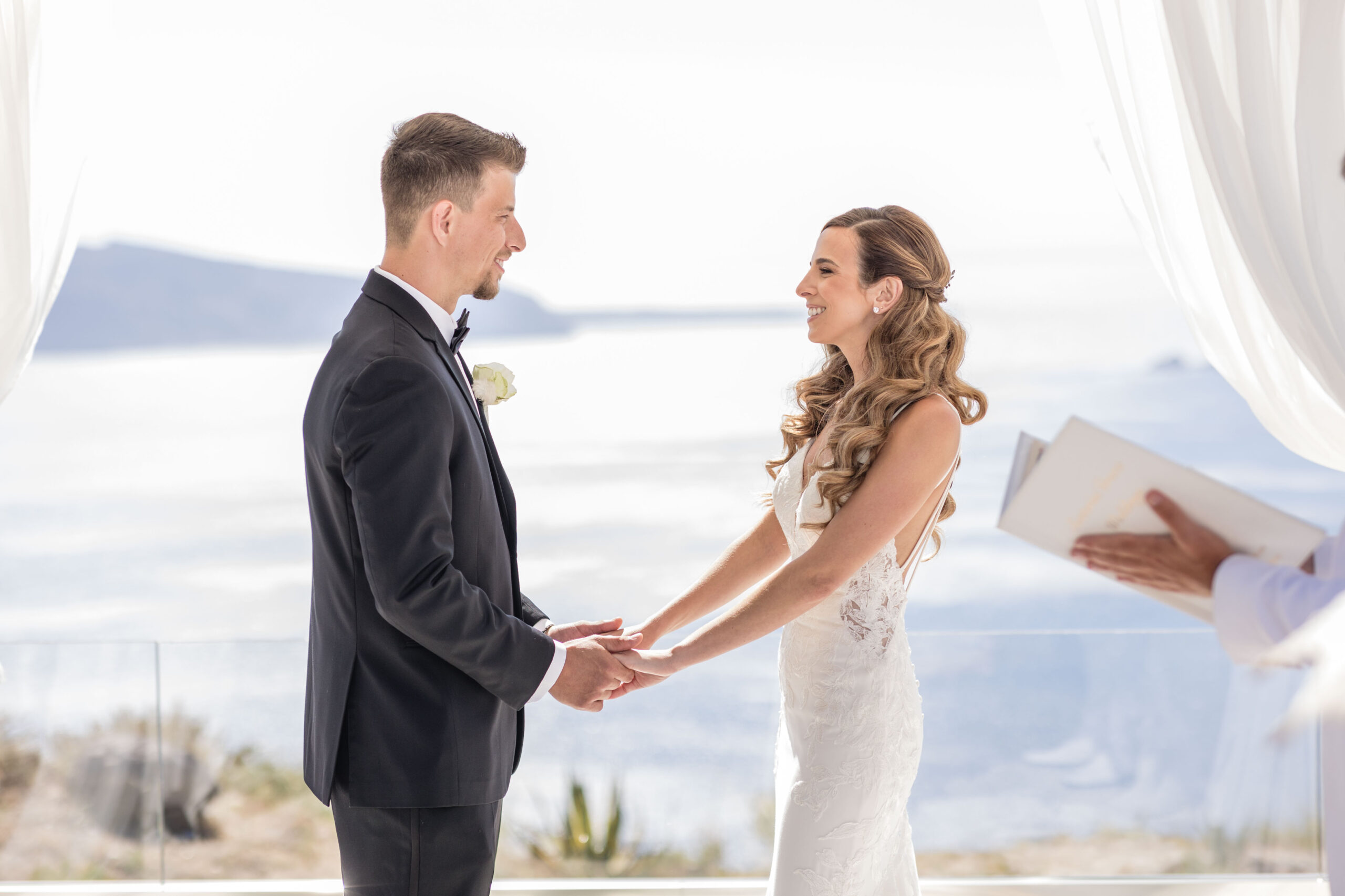 close up of bride and groom holding hands during wedding reading