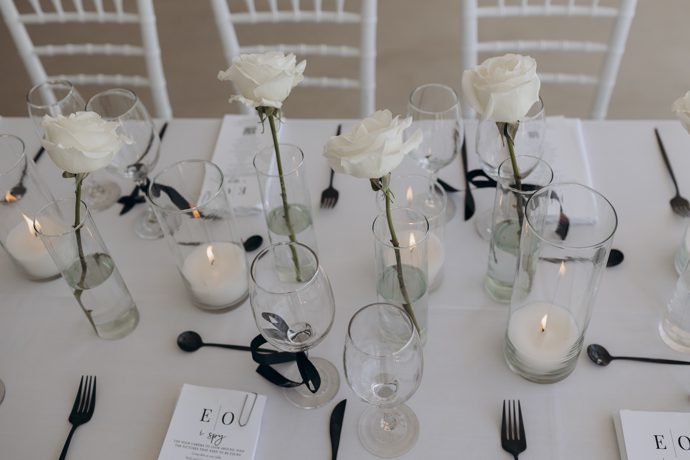 white roses in vases on wedding table at Le Ciel