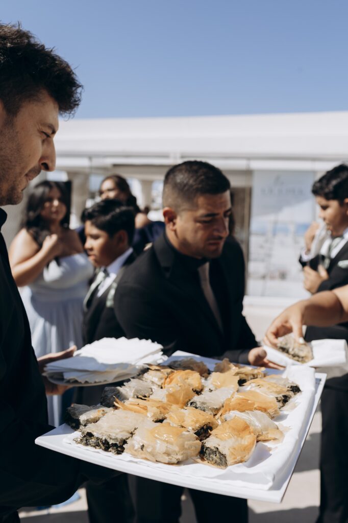 waiters serving greek food during drinks reception