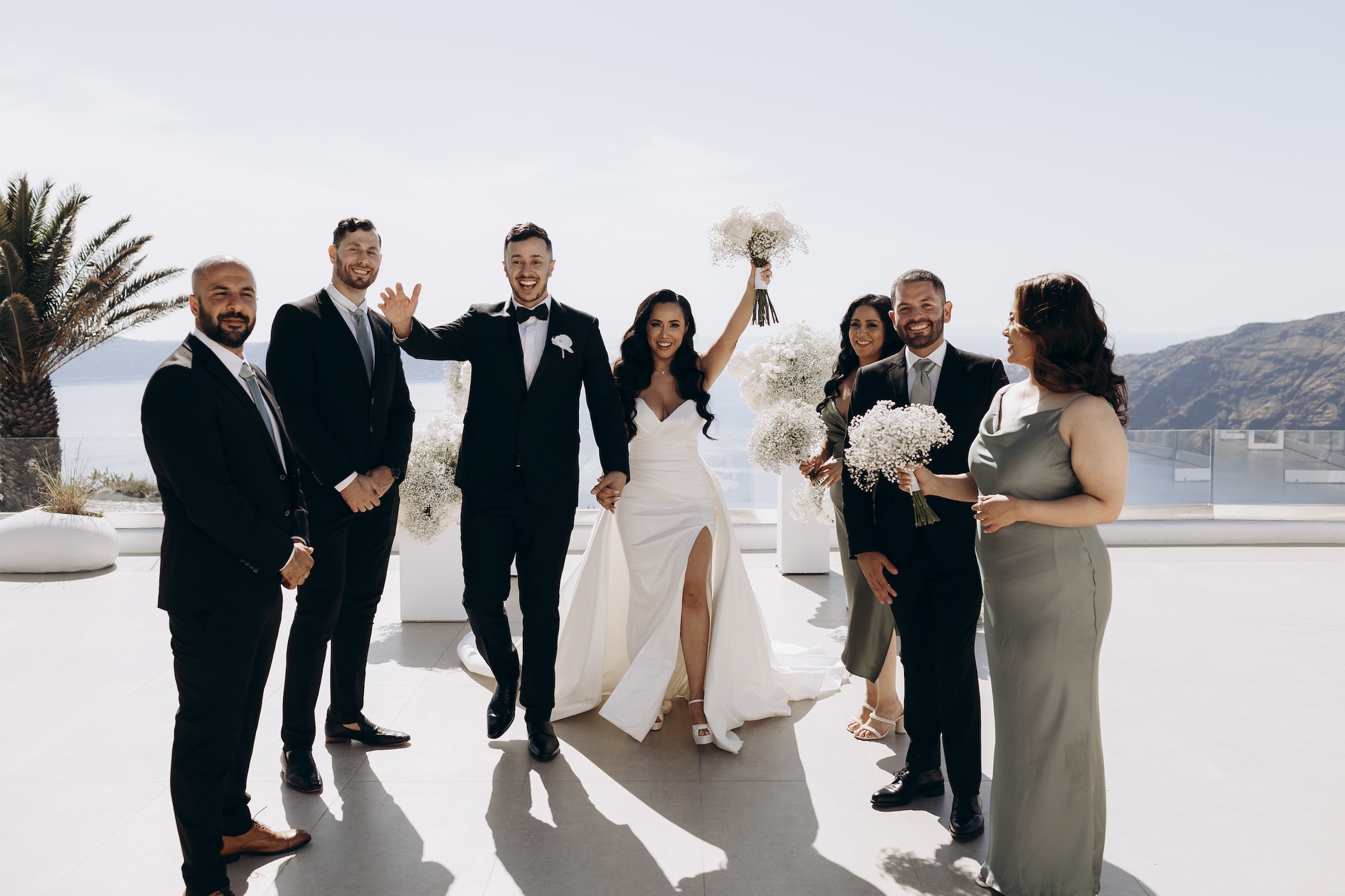 wedding party standing around groom and bride