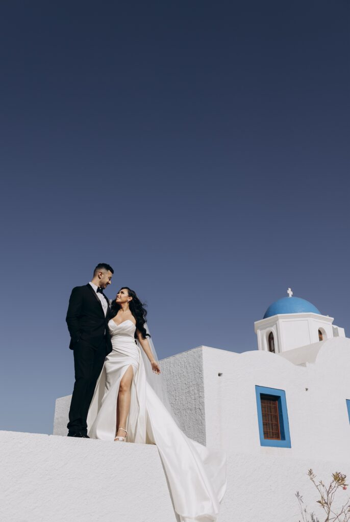 bride and groom posing on streets of Santorini