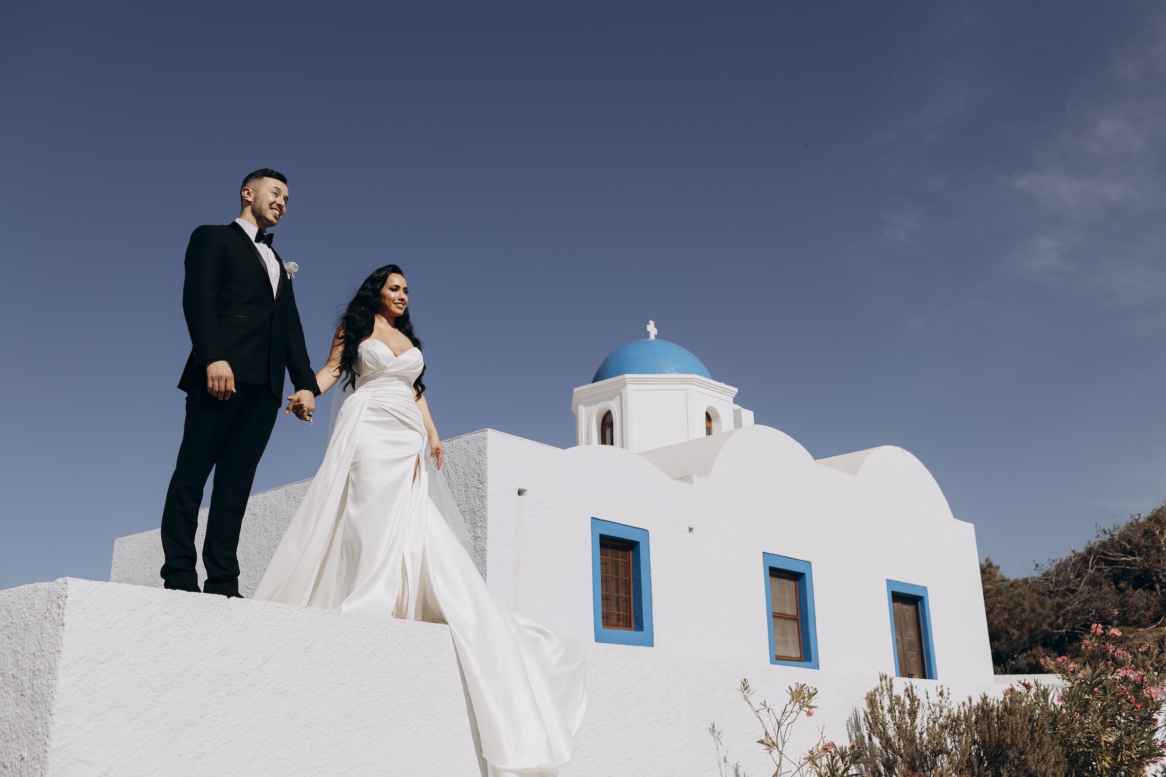 emily and omar standing next to white building with blue dome