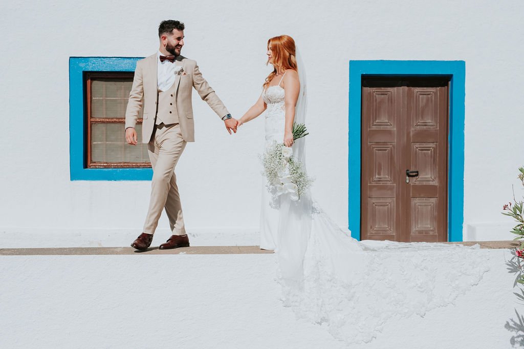 bride and groom walking through Santorini streets